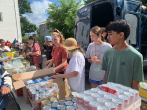 neighbors in need staff unloading car of donations