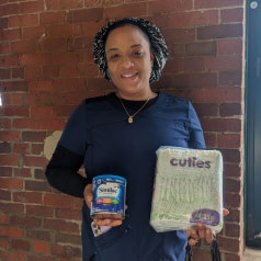 woman holding donated baby supplies