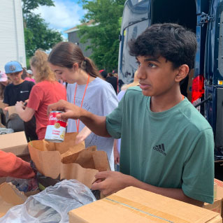 young boy handing out food