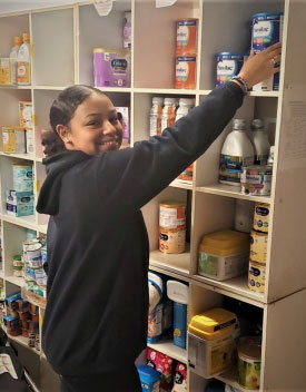 young woman volunteering at neighbors in need